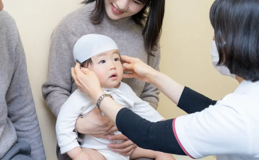 赤ちゃんの頭の形を測定する様子の写真